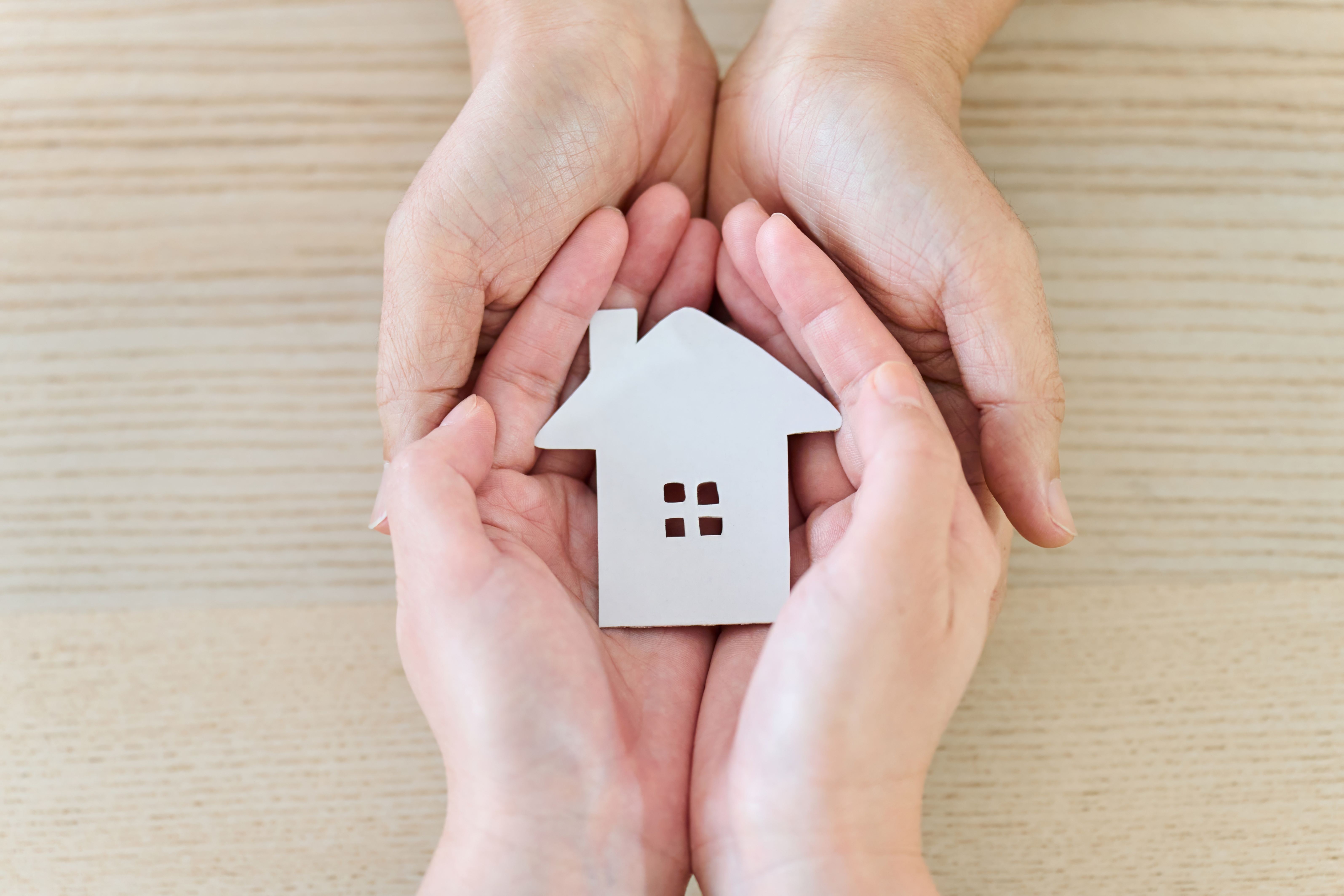 家を包み込む夫婦・カップルの手